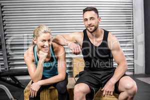 Fit couple sitting on wooden box