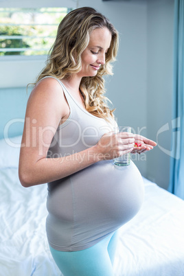 Pregnant woman taking a pill