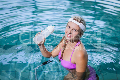 Fit woman doing underwater bike and drinking water