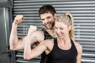 Fit couple showing muscular arms