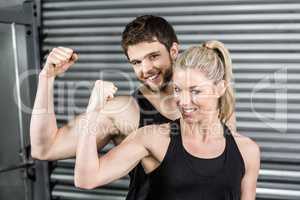 Fit couple showing muscular arms