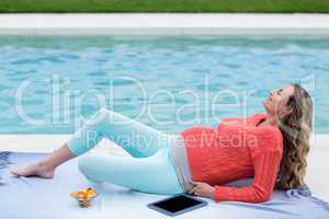 Pregnant woman relaxing outside and using tablet