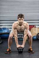 Shirtless man lifting dumbbells