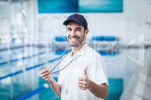 Happy trainer holding stopwatch with thumbs up
