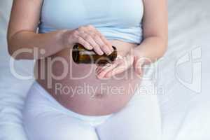 Pregnant woman taking a pill