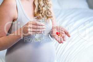 Pregnant woman taking a pill