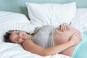 Pregnant woman lying on her bed