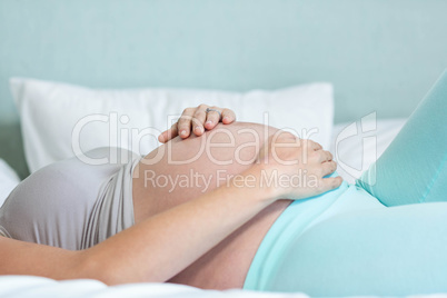 Pregnant woman lying on her bed