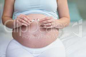 Pregnant woman cutting a cigarette in two
