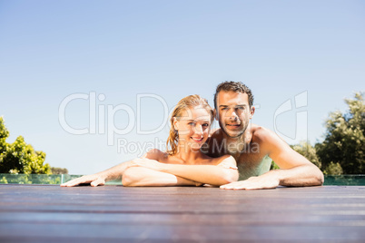 Happy couple leaning on pool edge