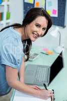 Pregnant woman writing on clipboard