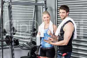 Smiling fit couple taking notes