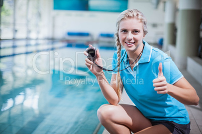 Fit trainer showing stopwatch with thumbs up