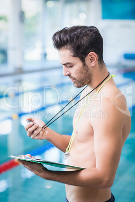 Handsome man holding clipboard and stopwatch