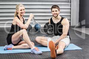 Couple sitting on fitness mat