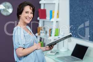 Pregnant woman reading notebook