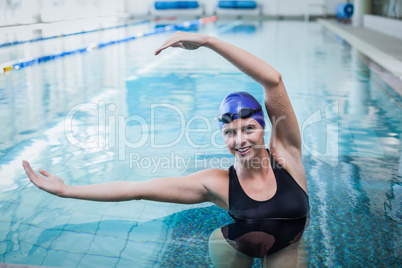 Fit woman stretching her arms in the water