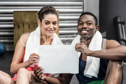 Smiling woman and man holding piece of paper
