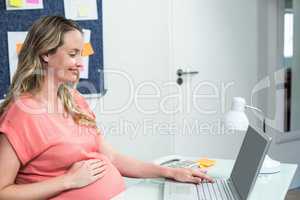 Pregnant woman using laptop