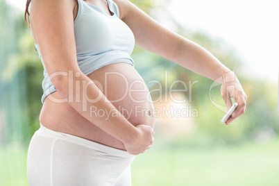 Pregnant woman taking a picture of her belly