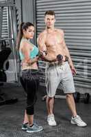 Fit couple lifting dumbbells