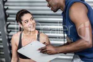 Athletic trainer explaining workout plan to woman