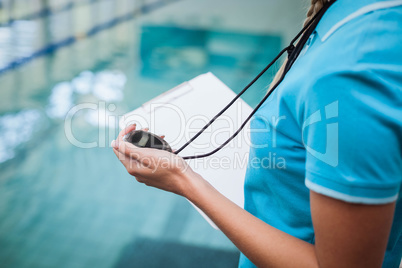 Pretty trainer looking at stopwatch