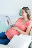 Pregnant woman writing on notepad