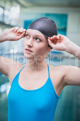 Pretty woman putting on swim cap