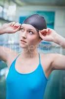 Pretty woman putting on swim cap