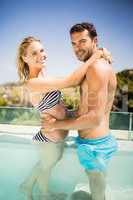 Happy couple embracing in the pool