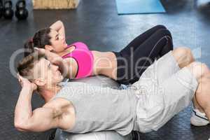 Athletic woman and man doing crunches