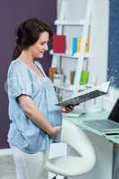 Pregnant woman reading notebook