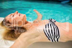 Peaceful woman floating in the pool