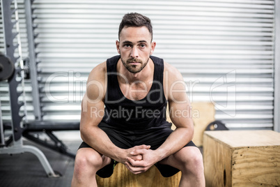 Fit man sitting on wooden box