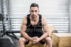 Fit man sitting on wooden box