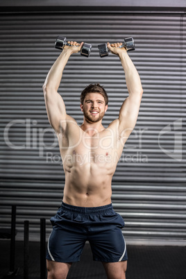 Front view of smiling man lifting weight