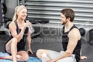 Couple sitting on fitness mat