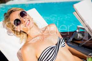 Smiling blonde lying on deck chair