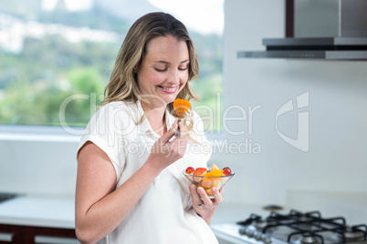 Pregnant woman eating fruits salad