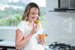 Pregnant woman eating fruits salad
