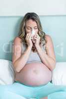 Pregnant woman blowing her nose