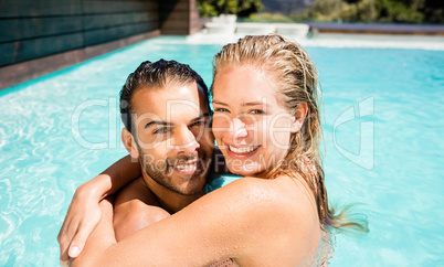 Happy couple embracing in the pool