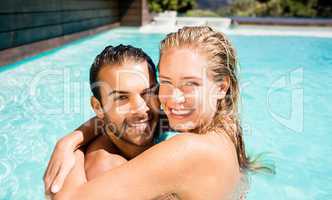 Happy couple embracing in the pool