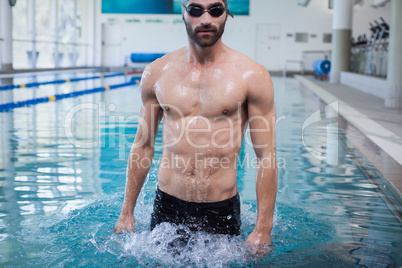 Focused man wearing swim cap and goggles