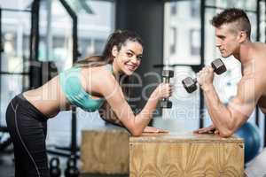 Fit couple lifting dumbbells