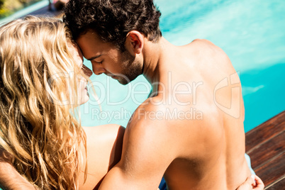 Rear view of couple sitting by the pool