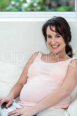 Pregnant woman relaxing with her laptop