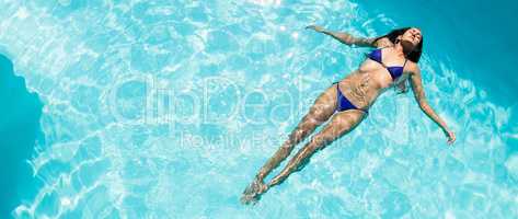 Calm woman floating in the pool