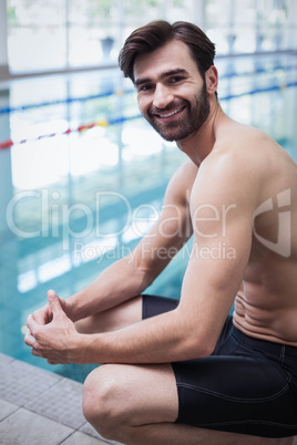 Smiling man sitting at the edge of the water